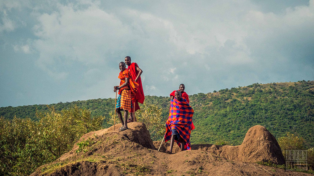 Four Kenyan people standing on a cliff.